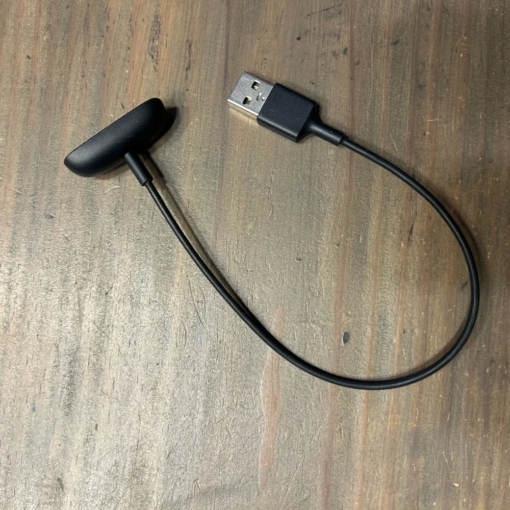 Black and White Fitness Tracker (FitBit with charger)